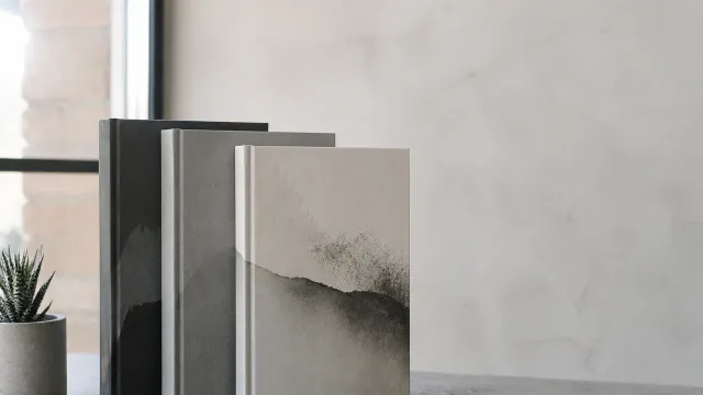 Stack of hardcover books on an industrial desk